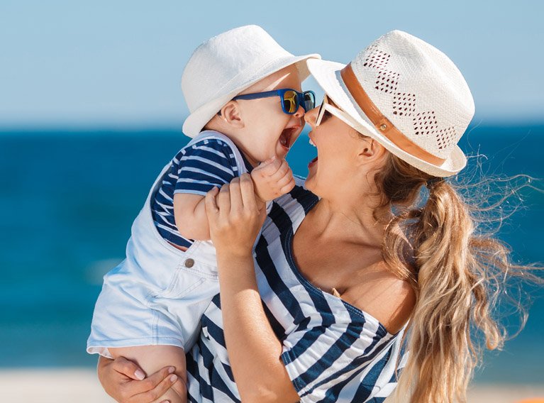 Mãe com criança na praia no Algarve - Reserve as suas férias com desconto