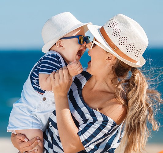 Mãe com criança na praia no Algarve - Reserve as suas férias com desconto